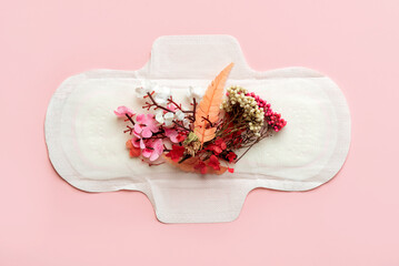 Top view of sanitary pads and flower bouquets. Concept of menstruation
