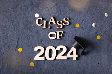 Class of 2024 concept. Number 2024 with graduated cap on dark background top view