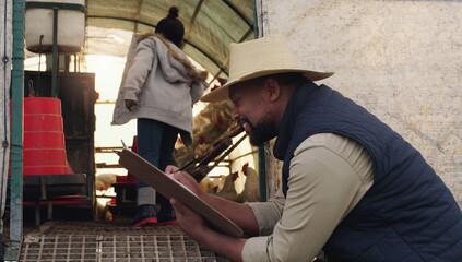 Black man, farmer and writing with clipboard for cattle, inspection or counting chickens in barn. African male person taking notes with livestock or animals for agriculture or production on farm