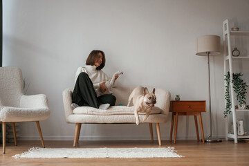 Young woman is with her pug dog at home