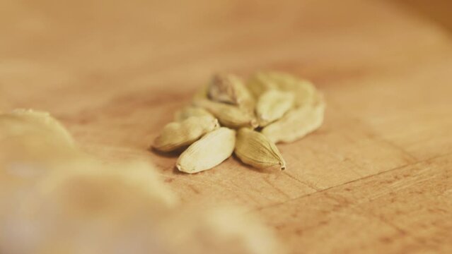 Cardamom, cardamon seeds on a wooden rustic table. Close up, macro. Slow motion handheld shot. High quality 4k footage