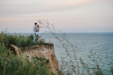Man and woman embrace on sand sea spending time together. Couple in love standing and hugging on...