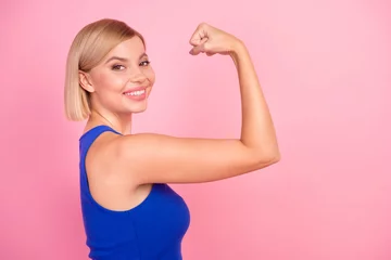 Foto op Canvas Profile photo of pretty young woman show flex biceps empty space wear blue top isolated on pink color background © deagreez