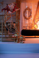 Elegant Wedding Stage Decoration with Peach and Gold Drapes, Floral Arrangements, and White Sofa