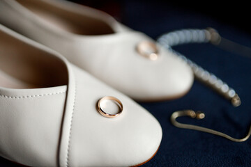 Bride's white wedding shoes and wedding rings