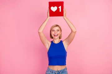 Rolgordijnen Photo of pretty young woman hands hold like icon wear blue top isolated on pink color background © deagreez