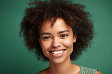 Beautiful African American woman smiling against green background.