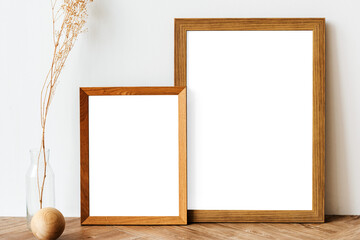 Picture frame mockups on a wooden sideboard table with dried flowers in a vase