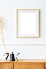 Picture frame mockup over a wooden sideboard table with dried flowers in a pour-over glass