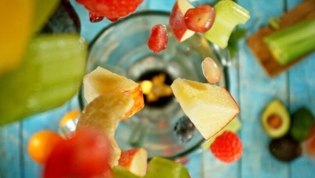 Freeze motion of mixing pieces of fruit and vegetables in blender, top shot