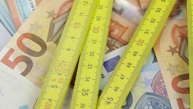M&egrave;tre pliant, maison et billets de banque, en gros plan.