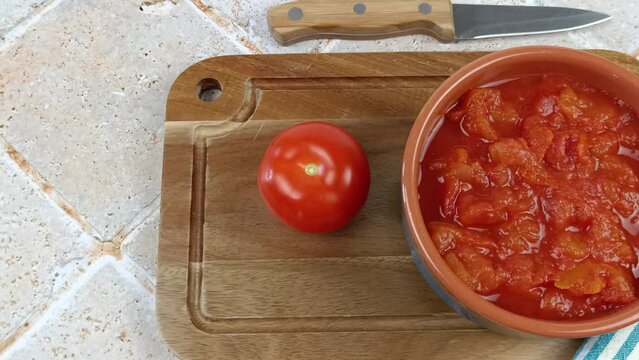 bol de tomates concass&eacute;es, en gros plan, sur une planche &agrave; d&eacute;couper	