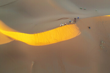 Tourists in the Sahara Desert on sandboarding
