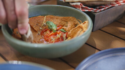 Man hands taking hummus with pita at restaurant table closeup. Guy enjoying food