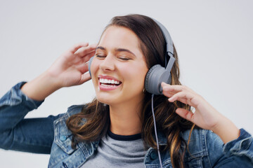 Headphones, dance or happy woman streaming music in studio for singing on grey background to relax....