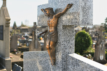 Crucified Jesus Christ on a cross on a grave in a cemetery