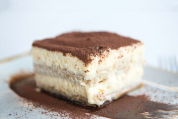 tiramisu dessert in a white plate on a white background