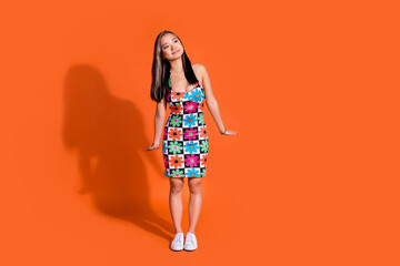 Full length photo of cheerful nice woman dressed flower print clothes look at discount empty space isolated on orange color background