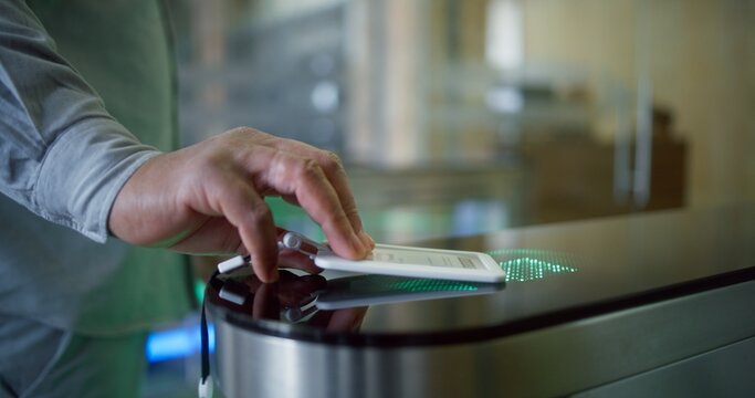 Caucasian man or businessman walks through the gates into business center using electronic pass card. Turnstile with touch panel for automatic scanning and identification in modern office building. - Powered by Adobe