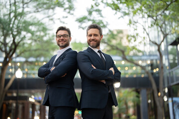  businessmans in casual attire looking at camera. two businessmen in suits with their arms crossed...
