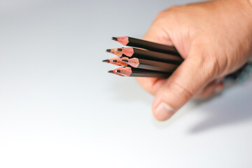 Holding black color pencils with isolated and white background.