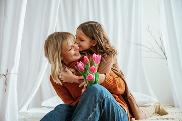 Flowers in hands. Mother's day concept. Female parent with daughter is at home - 788364730