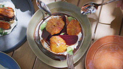 Closeup hands taking appetizer meal with spoons and fork at vegan restaurant