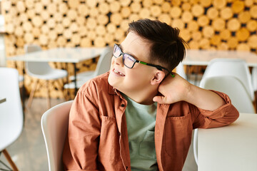 joyous preadolescent inclusive boy with Down syndrome in casual attire looking away while in cafe