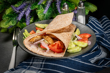 Wholegrain tortilla wraps with vegetables and chicken on a plate. - 788370789
