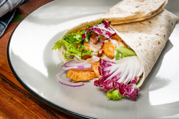 Wholegrain tortilla wraps with vegetables and chicken on a plate. - 788370993