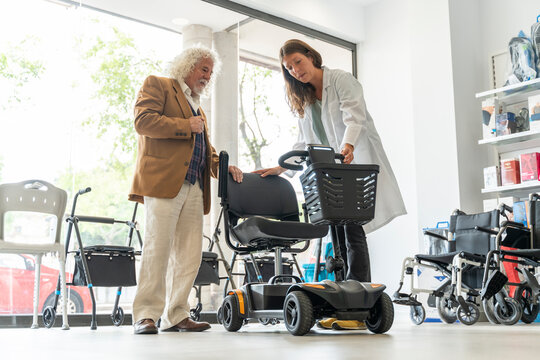 Older man in an orthopedic shop trying out an electric scooter - Powered by Adobe