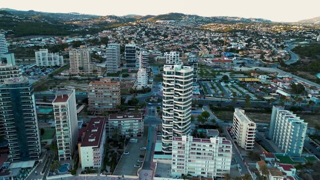 Skyscrapers of Calpe perspective from above. Drone descending. Cantal Roig Beach. Panoramic view of Calpe city, beautiful and touristic travel destination in Alicante, Spain. Sunset point. Coastline