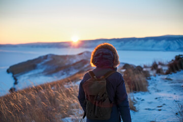 Young man standing in winter frozen nature. Ogoy island, lake Baikal, Siberia, Russia