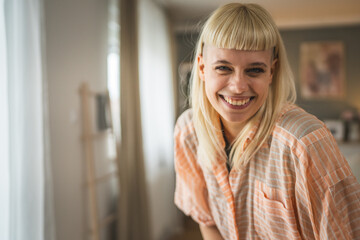 Portrait of young blonde woman at home happy positive