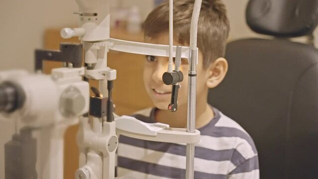 Doctor optometrist checks little boy's eyesight. Child in ophthalmologist room.