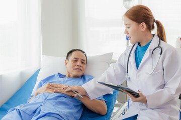 Fototapeta premium Young Asian female doctor talking with elderly man Provide care and assistance to patients in hospital beds Elderly health care and medicine