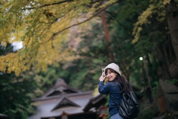 Asian woman in casual dress immerses herself in the cultural richness of Japanese shrines and temples, finding joy and peace in the heart of Tokyo and Kyoto.