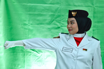 Close up photo young girl Indonesian National Flag Hoisting Troop looking to the copy space. National Paskibraka Council isolated in green background
