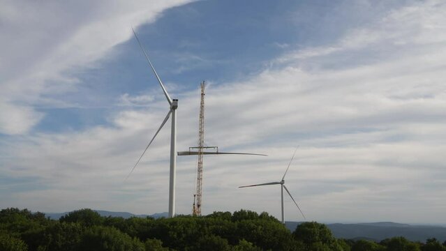 
Timelapse of Building process of wind energy power tower mill, under construction. Crane lifting up wind turbine propeller, installation of rotor blades. Green, clean, renewable energy. 

