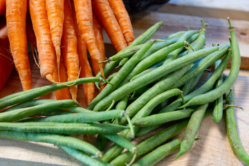 Bunch on fresh orange carrots and green beans on wooden box - Powered by Adobe