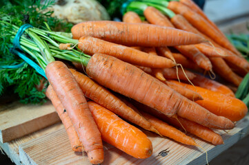 Bunch on fresh orange carrots with green on wooden box - 788396981