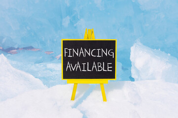 Financing available symbol. Concept words Financing available on beautiful yellow black blackboard. Beautiful blue ice background. Business financing available concept. Copy space.
