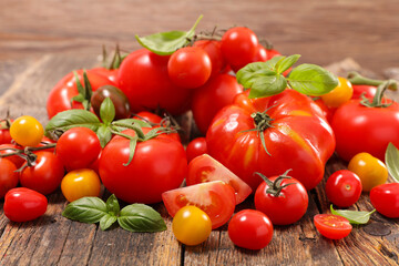assorted of fresh tomatoes and basil on wood background