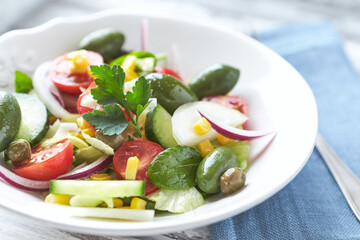 Simple Salad with Green Olives, Cucumber and Cherry Tomatoes. Bright wooden background.