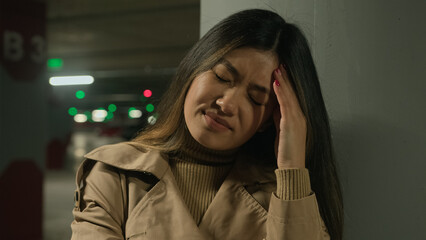 Sick Asian woman suffer headache in parking painful head migraine ache health problem high blood...
