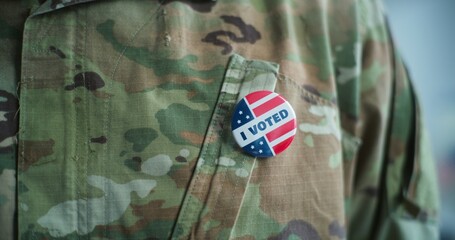 Close up of military man putting on badge with American flag logo and inscription I Voted. US citizen, voter at polling station during elections. National Election Day in the United States of America.