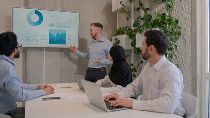 Office team leader man mentor show charts financial growth graphics presentation on interactive...