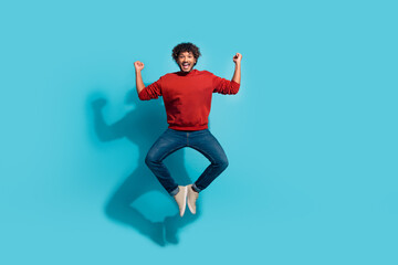 Full body length photo of funny mexican guy in red sweatshirt jump fists up sports fan support basketball team over cyan color background