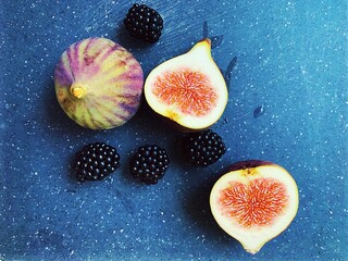 figs and blackberries, cut fresh figs, dark blackberry fruits on a wooden board, fresh vitamins