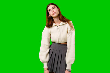 Woman in Skirt and Sweater Standing Against Green Background - 788422721